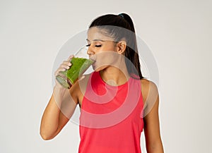 Happy beautiful fit sport woman smiling and drinking healthy fresh vegetable smoothie