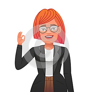 Happy beautiful girl in a business suit with red hair shows an OK gesture. Stylish young confident woman in glasses