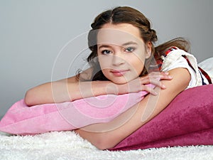 The happy beautiful girl lies on pink pillows
