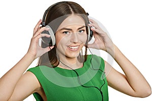 Happy beautiful girl listening to music in headphones