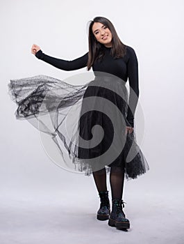 Happy beautiful girl model in black dress posing in studio isolated on white background,Teen girl in black tulle skirt , Full