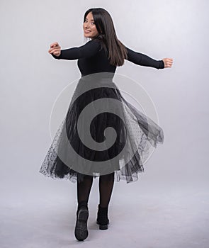 Happy beautiful girl model in black dress posing in studio isolated on white background,Teen girl in black tulle skirt , Full