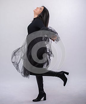 Happy beautiful girl model in black dress posing in studio isolated on white background,Teen girl in black tulle skirt , Full