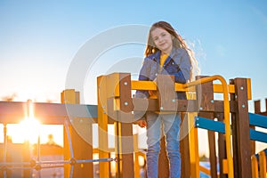 Happy beautiful girl playing on the beach playground against sunset sky