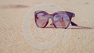 Happy Beautiful Girl Reflecting in Sunglasses laying on the Pure White Sand Beach, Bali