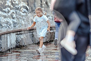 Happy beautiful girl running through the spray of water