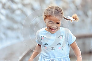 Happy beautiful girl running through the spray of water