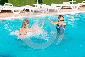 Happy beautiful girls having fun at the pool