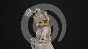 Happy beautiful little baby girl in glossy dress. Christmas. Make faces