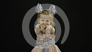 Happy beautiful little baby girl in glossy dress. Christmas. Make faces