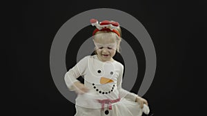 Happy beautiful little baby girl in snowman costume. Make faces, dance