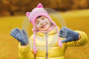 Happy beautiful little girl waving hands outdoors