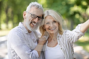 Happy beautiful mature couple posing for selfie together outdoors