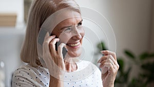 Happy beautiful mature woman making phone call close up photo