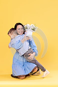 Happy beautiful mommy playing with cute little son indoors