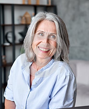 Happy beautiful old female businesswoman smiling looking away in office.