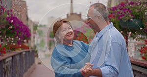 Happy beautiful senior couple dancing in park. Full length portrait of cheerful active retired man and woman dancing and
