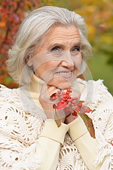 Happy beautiful senior woman posing in autumn park