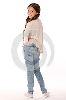 Happy beautiful smiling slender child girl in blue jeans