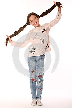 Happy beautiful smiling slender child girl in blue jeans