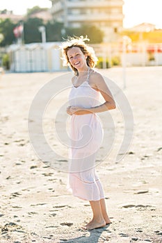 Happy beautiful smiling young woman enjoy sun and wind at the sand beach