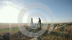 Happy beautiful wedding couple bride and groom at wedding day outdoors on the mountains rock