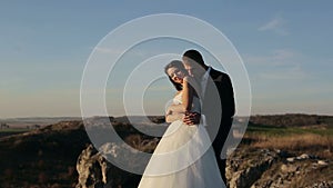 Happy beautiful wedding couple bride and groom at wedding day outdoors on the mountains rock