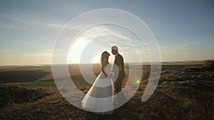 Happy beautiful wedding couple bride and groom at wedding day outdoors on the mountains rock