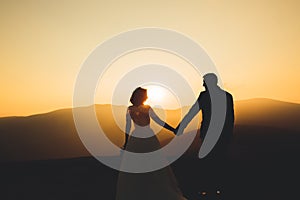 Happy beautiful wedding couple bride and groom at wedding day outdoors on the mountains rock. Happy marriage couple