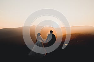 Happy beautiful wedding couple bride and groom at wedding day outdoors on the mountains rock. Happy marriage couple