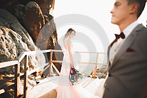 Happy beautiful wedding couple bride and groom at wedding day outdoors on the mountains rock. Happy marriage couple