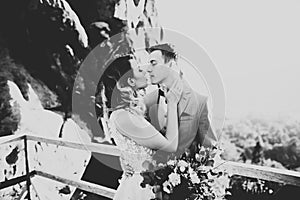 Happy beautiful wedding couple bride and groom at wedding day outdoors on the mountains rock. Happy marriage couple