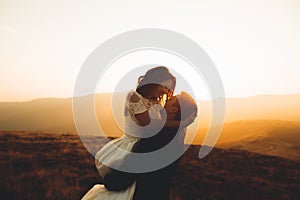 Happy beautiful wedding couple bride and groom at wedding day outdoors on the mountains rock. Happy marriage couple