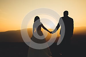 Happy beautiful wedding couple bride and groom at wedding day outdoors on the mountains rock. Happy marriage couple