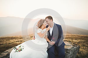 Happy beautiful wedding couple bride and groom at wedding day outdoors on the mountains rock. Happy marriage couple