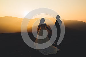 Happy beautiful wedding couple bride and groom at wedding day outdoors on the mountains rock. Happy marriage couple