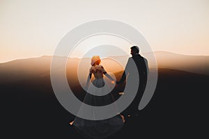 Happy beautiful wedding couple bride and groom at wedding day outdoors on the mountains rock. Happy marriage couple