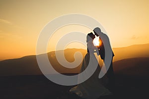 Happy beautiful wedding couple bride and groom at wedding day outdoors on the mountains rock. Happy marriage couple