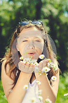 Happy beautiful woman blowing dandelion over