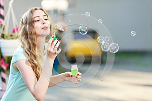 Happy woman blowing soap bubbles