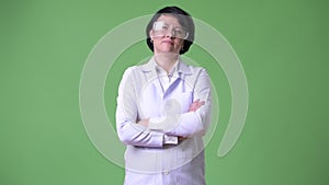 Happy beautiful woman doctor wearing protective glasses with arms crossed