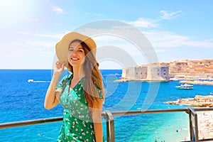 Happy beautiful woman enjoying her cruise in Mediterranean Sea. Smiling traveler girl enjoying her summer holidays in Dubrovnik,