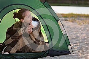 Happy beautiful woman enjoys sunny morning in camp. Concept of travelling, hiking, camping