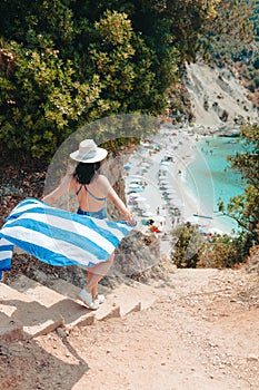 happy beautiful woman with greece flag running to the sea beach