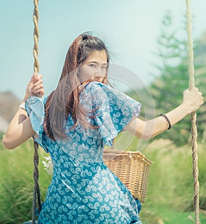 Happy beautiful woman having relax time on a swing in nature field for nature hapiness lifestyle