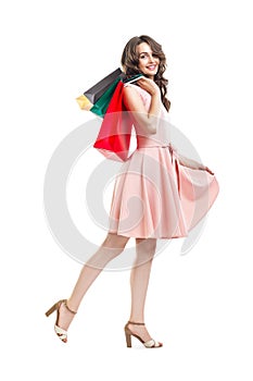 Happy beautiful woman holding many colorful shopping bags isolated on white background