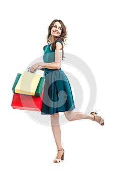 Happy beautiful woman holding many colorful shopping bags isolated on white background