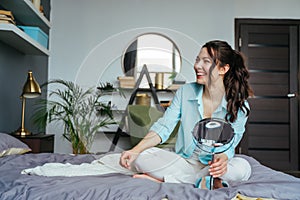 Happy beautiful woman in the house posing near the mirror, looking at the camera with a smile