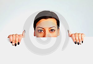 Happy beautiful Woman peeking behind a whiteboard