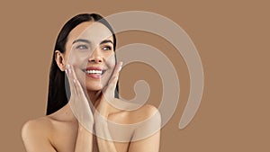 Happy beautiful woman posing naked over beige background, copy space
